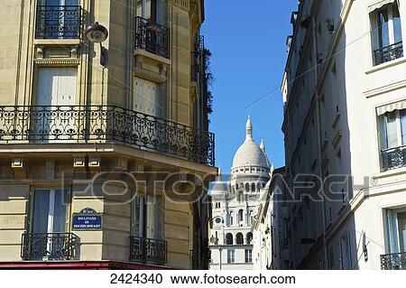 Stock Image - Residential buildings with the dome roof of the Basilica of the Sacred Heart of Paris viewed between the buildings; Paris, France. Fotosearch