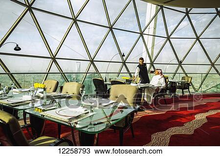Stock Image - Restaurant with large windows to view the city; Riyadh, Saudi Arabia. Fotosearch