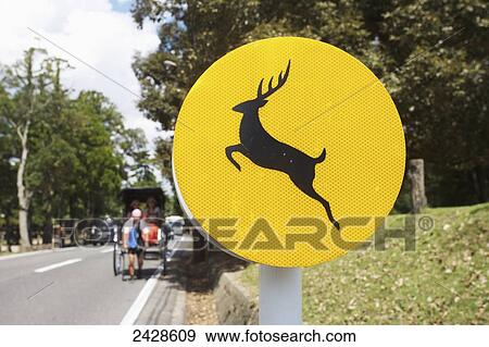 Stock Photo - Rickshaw puller and deer sign on the road; Nara, Japan. Fotosearch