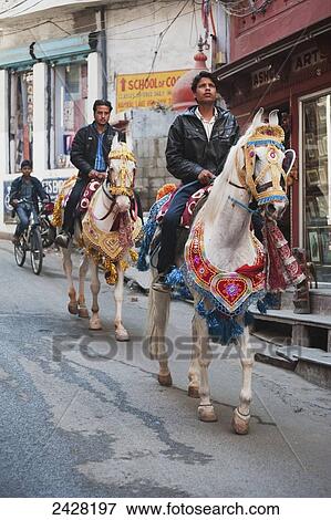 Riding horseback on the street; India View Large Photo Image Stock Photo - Riding horseback on the street; India. Fotosearch