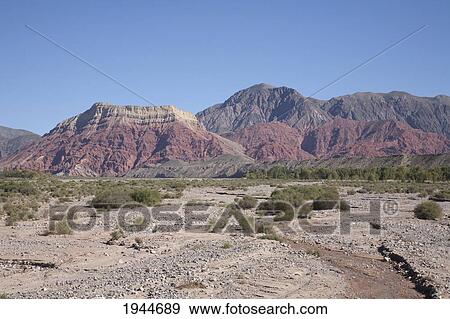 Stock Photo - Rio Grande and the multicolored mountains of the Quebrada de Humahuaca between the towns of Humahuaca and Huacalera, Jujuy, Argentina. Fotosearch