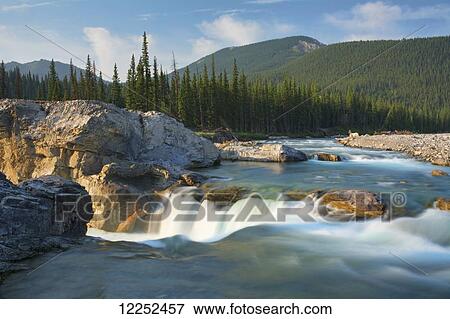 Stock Photo - River and waterfall in morning light; Bragg Creek, Alberta, Canada. Fotosearch
