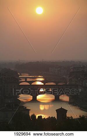 River Arno and famous bridge Ponte Vecchio, the oldest in Florence at sunset. Photo from hillside at large square Piazzale Michelangelo overlooking Firenze/ Florence city in Tuscany. Italy. June. View Large Photo Image Picture - River Arno and famous bridge Ponte Vecchio, the oldest in Florence at sunset. Photo from hillside at large square Piazzale Michelangelo overlooking Firenze/ Florence city in Tuscany. Italy. June.. Fotosearch