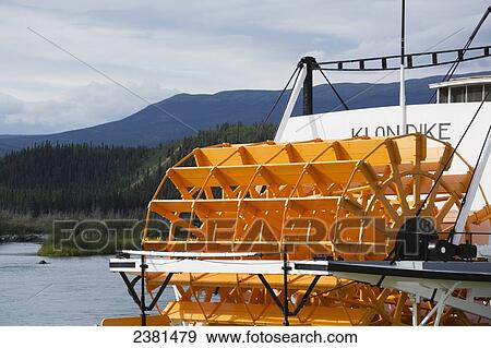 Stock Photo - Riverboat with large yellow wheel on the Yukon River; Whitehorse, Yukon, Canada. Fotosearch