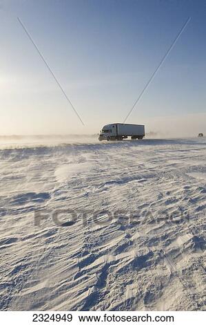 Stock Photo - Road covered with blowing snow; Morris, Manitoba, Canada. Fotosearch