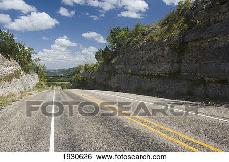 Stock Photograph - Road stretching into the distance on Route 16 in Bandera County, Texas, USA. Fotosearch