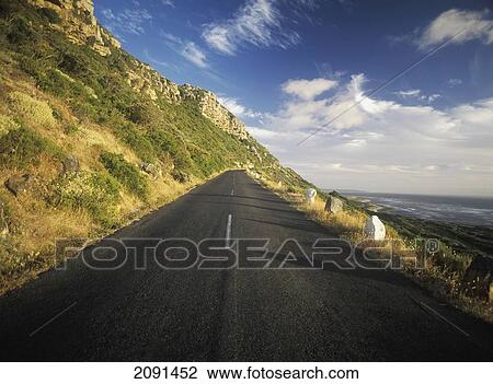 Stock Image - Road Up Hill At Dusk Beside The Coast Near Kommitjie, Cape Peninsula, South Africa.. Fotosearch