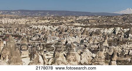 Stock Photo - Rock Formations And A Cityscape; Goreme Nevsehir Turkey. Fotosearch