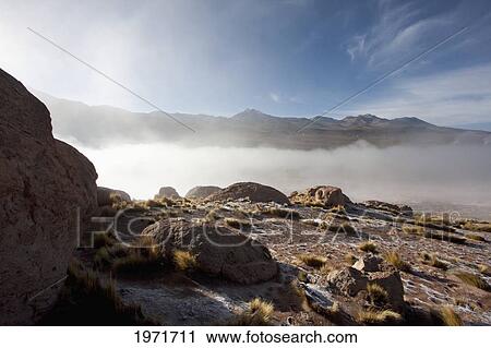 Stock Image - Rock In Front Of The El Tatio Geysers Covered By Fog At Dawn, Antofagasta Region, Chile. Fotosearch