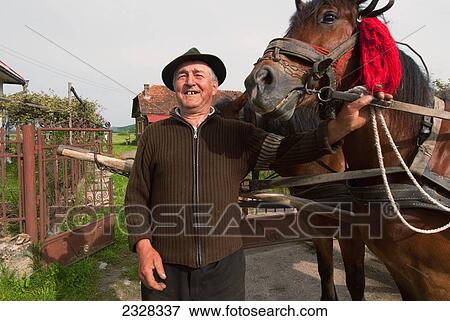 Stock Photo - Romania, Portrait of senior man with horse; Maramures. Fotosearch