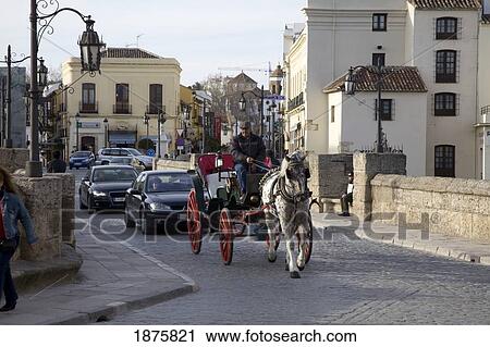 Stock Image - Ronda, Andalusia, Spain; A Horse And Carriage Followed By Cars Going Over The Bridge. Fotosearch