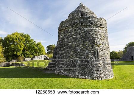 Stock Photo - Round stone castle struture in grassy field with blue sky and clouds; County Galway, Ireland. Fotosearch
