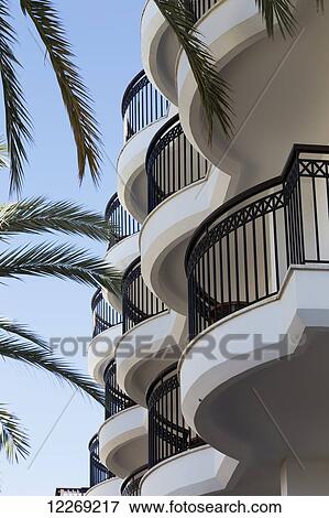 Stock Photo - Rounded balconies on a residential building with palm fronds and blue sky; Paphos, Cyprus. Fotosearch