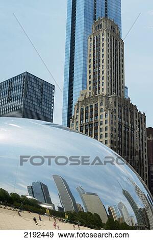 Stock Photo - Rounded Silver Sculpture Reflecting Pedestrians And Buildings With Skyscrapers In The Background; Chicago Illinois United States Of America. Fotosearch