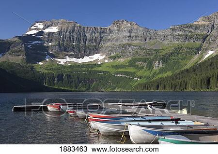 Row Boats Along A Dock In A Lake With Mountains In The Background; Waterton, Alberta, Canada View Large Photo Image Stock Image - Row Boats Along A Dock In A Lake With Mountains In The Background; Waterton, Alberta, Canada. Fotosearch