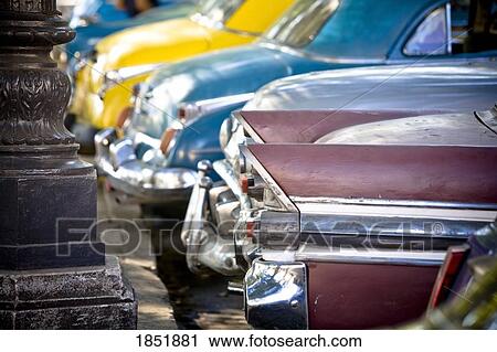 Stock Image - Row Of Colorful Parked Cars; Havana, Cuba. Fotosearch