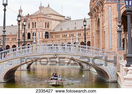 Stock Photo - Rowboat Under Bridge On Canal, Plaza De Espana, Maria Luisa Park; Seville, Andalucia, Spain, Europe. Fotosearch