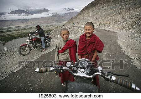 Royal Enfield Bullet Motorbike With Buddhist Boy Monks; Nubra Valley, Ladakh, India View Large Photo Image Stock Image - Royal Enfield Bullet Motorbike With Buddhist Boy Monks; Nubra Valley, Ladakh, India. Fotosearch