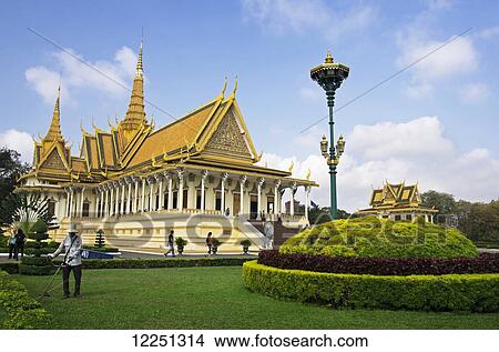 Picture - Royal Palace, home of the King, as gardener works on the lawn and tourists stroll the grounds; Phnom Penh, Cambodia. Fotosearch