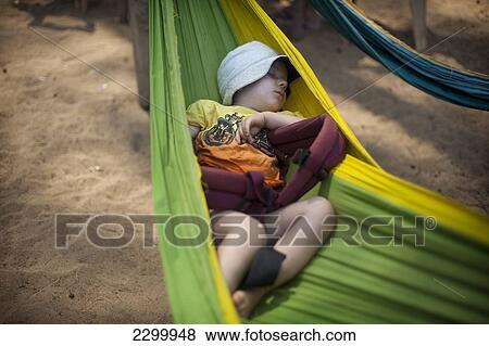 Stock Photo - Rudi Mchugh sleeps happily in a hammock on Turtle Beach, Goa, India.. Fotosearch