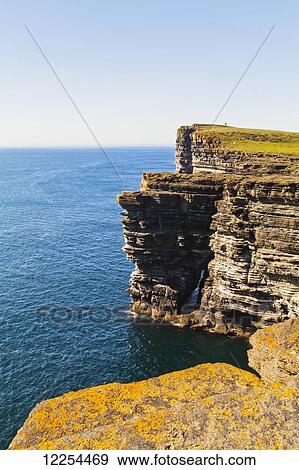 Stock Photo - Rugged cliffs along the coastline of Orkney Islands; Orkney, Scotland. Fotosearch