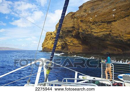Picture - Rugged rock on the coastline of an hawaiian island as viewed from the bow of a boat; Hawaii, United States of America. Fotosearch