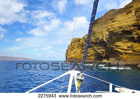 Stock Image - Rugged rock on the coastline of an hawaiian island as viewed from the bow of a boat; Hawaii, United States of America. Fotosearch