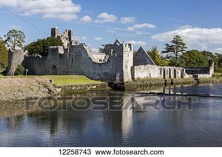 Ruined stone castle reflecting along river's edge with trees, blue sky and clouds; Adare, County Limerick, Ireland View Large Photo Image Stock Image - Ruined stone castle reflecting along river's edge with trees, blue sky and clouds; Adare, County Limerick, Ireland. Fotosearch