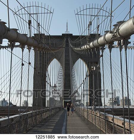Stock Photography - Runners on a wooden boardwalk on a bridge; New York City, New York, United States of America. Fotosearch