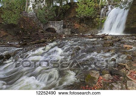 Stock Image - Running stream and waterfall in Autumn at Hilton Falls; Campbellville, Ontario, Canada. Fotosearch