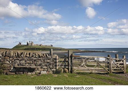 Stock Image - Rural Fence With Dunstanburgh Castle; Northumberland, England. Fotosearch