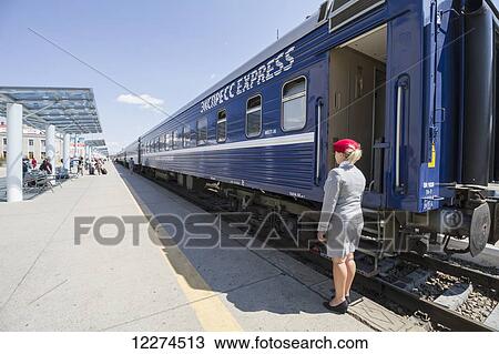 Stock Image - Russian conductor standing by the Trans-Mongolian train at the Ulaanbaatar Railway Station, Ulaanbaatar (Ulan Bator), Mongolia. Fotosearch