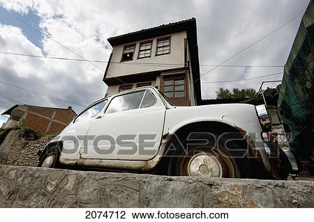 Stock Image - Rusting Car By A House, Ohrid, Macedonia. Fotosearch