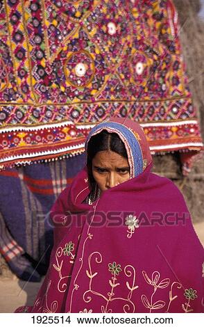 Picture - Sad, Upset, Worried Harijan Girl Dressed In Colourful Sari In Front Of Pink / Red Fabric / Material, Ludia Village, North Of Bhuj. Fotosearch