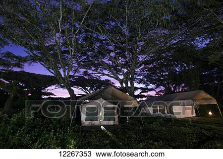 Stock Image - Safari camp tents at sunrise on the rim of Ngorongoro Crater; Tanzania. Fotosearch