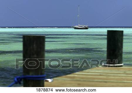 Picture - Sailboat Moored In Turquoise Waters Beyond A Pier. Fotosearch