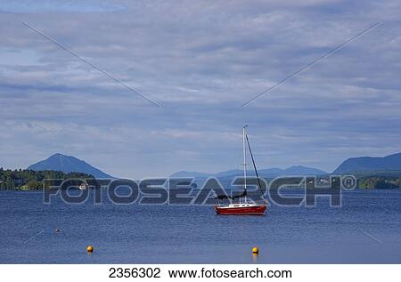 Stock Image - Sailboat On Lac Memphremagog In Early Morning With Mont Owls Head In Background; Magog, Quebec, Canada. Fotosearch