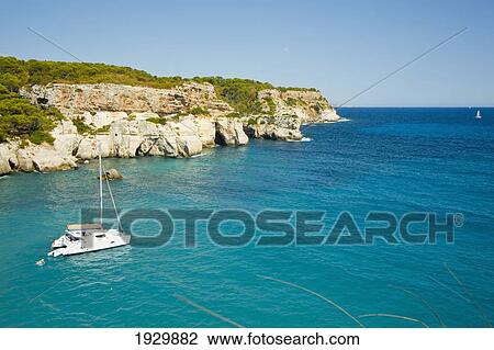 Stock Image - Sailing Boat At Cala Macarella, Menorca, Balearic Islands, Spain. Fotosearch