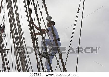 Picture - Sailor Climbing A Rig Of The Four-Mast Barquentine, Chilean Navy Training Ship Esmeralda In Hanga Roa Harbour, Rapa Nui (Easter Island), Chile. Fotosearch