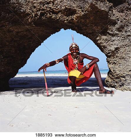 Stock Image - Samburu Tribesman Under Stone Arch On Diani Beach. Fotosearch