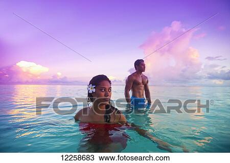 Stock Image - Samoan couple bathing in turquoise waters off Savaii Island; Samoa. Fotosearch