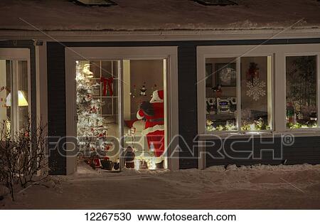 Stock Image - Santa Claus by the Christmas tree inside a house; Waterloo, Quebec, Canada. Fotosearch