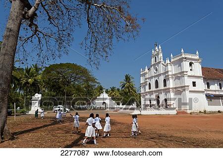 Stock Photo - School children playing in front of old Portuguese church; Goa, India. Fotosearch