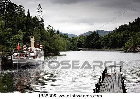 Stock Photography - Scotland; Tour Boat And Wooden Pier Over Lake. Fotosearch