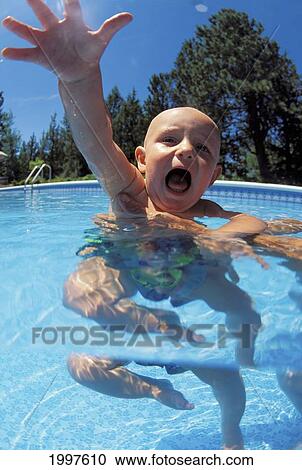 Stock Image - Screaming Bald Baby In Swimming Pool, Held By Adult Reaching For Camera. Fotosearch