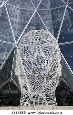Sculpture of a human head in front of a modern building of windows; Calgary, Alberta, Canada View Large Photo Image Stock Photograph - Sculpture of a human head in front of a modern building of windows; Calgary, Alberta, Canada. Fotosearch