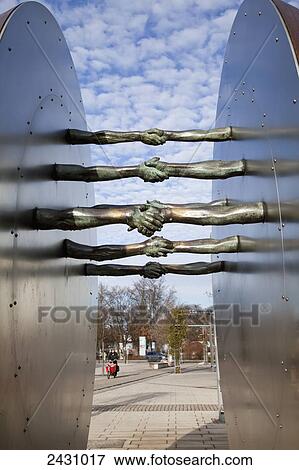 Stock Photo - Sculpture of arms outstretched into a handshake; Gilching, Bavaria, Germany. Fotosearch