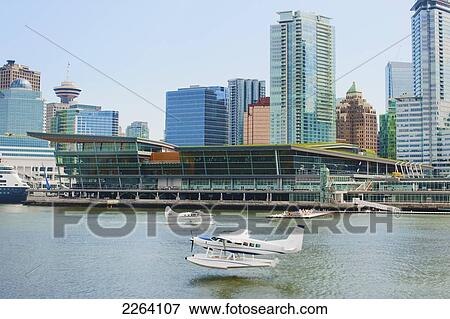 Stock Photo - Seaplane Taking Off At Vancouver Harbour Flight Centre With Convention Centre Backdrop; Vancouver British Columbia Canada. Fotosearch