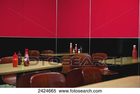 Stock Photography - Seating in a restaurant with a wall half black and half bright red; London, England. Fotosearch
