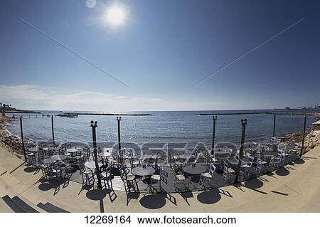 Picture - Seating on a patio at the water's edge with a view of the Mediterranean; Paphos, Cyprus. Fotosearch